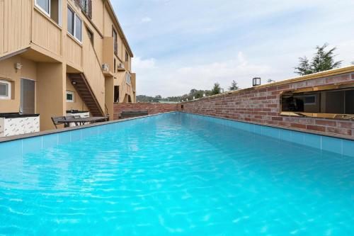 a large blue swimming pool next to a building at The Bay hotel & pool villa in Suncheon