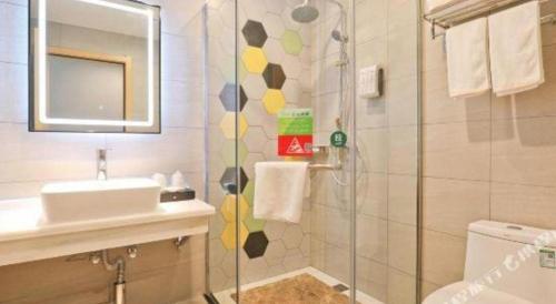 a bathroom with a shower and a sink and a sink at Vatica Hotel Hefei Yaohai Longgang Subway Station in Hefei