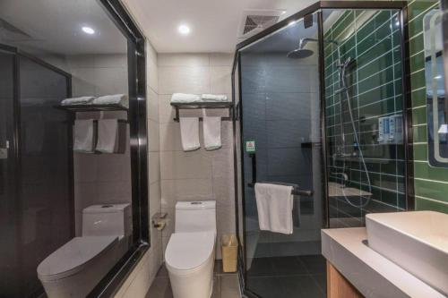 a bathroom with a toilet and a sink and a shower at GreenTree Inn Express Zhangjiagang Hexing Town Shazhou Professional Institue of Technology in Qiwei