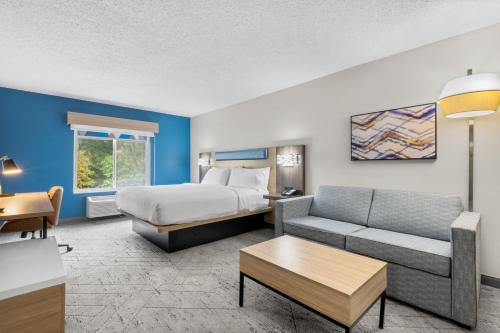 a hotel room with a bed and a couch at Holiday Inn Express Hartford-Newington by IHG in Newington