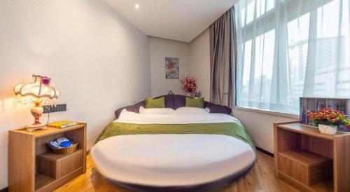a bedroom with a large bed and a window at GreenTree Inn Express Lanzhou West Passenger Station Lanzhou Center in Lanzhou