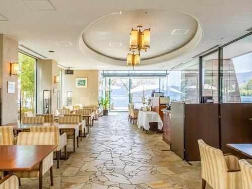 a restaurant with tables and chairs and windows at Hakone Hotel in Hakone