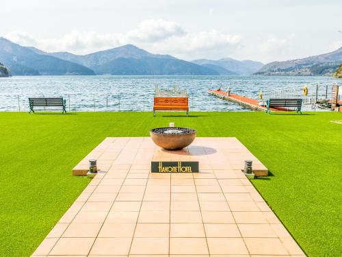a park with a large bowl in the grass next to the water at Hakone Hotel in Hakone
