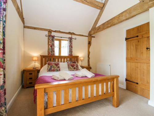 a bedroom with a wooden bed and a window at The Hayloft in Knighton
