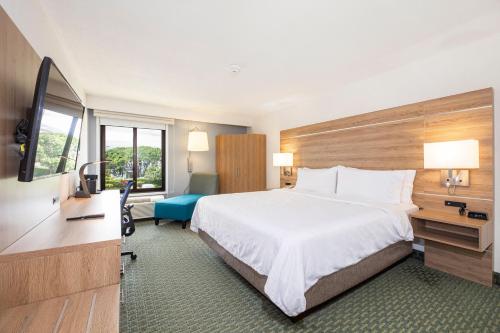 a hotel room with a bed and a flat screen tv at Holiday Inn Express San Jose Costa Rica Airport by IHG in Alajuela City