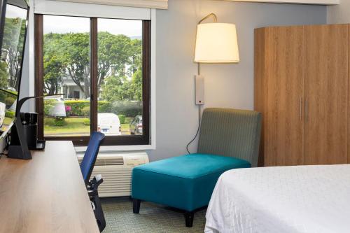 a hotel room with a bed and a chair and a window at Holiday Inn Express San Jose Costa Rica Airport by IHG in Alajuela City