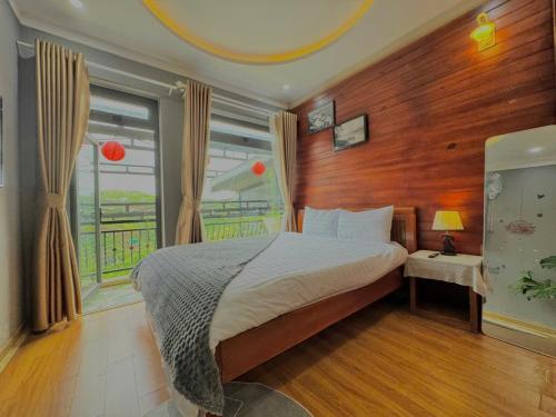 a bedroom with a bed and a large window at Pine Forest House Dalat in Xuan An