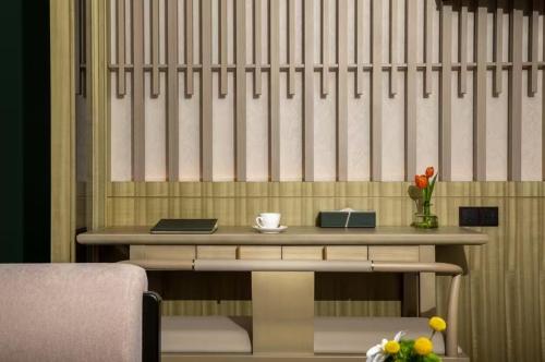 a table with a bench and a cup of coffee on it at Crowne Plaza Putian by IHG in Putian
