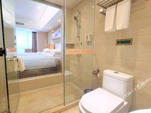 a bathroom with a shower and a toilet with a glass shower at Vienna Hotel Guangxi Guilin Xing'an in Guilin
