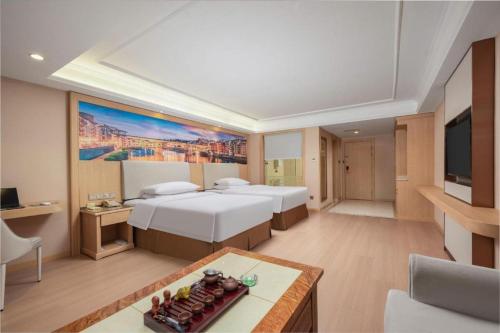a hotel room with two beds and a flat screen tv at Vienna Hotel Hubei Xiaogan Beijing Road in Xiaogan