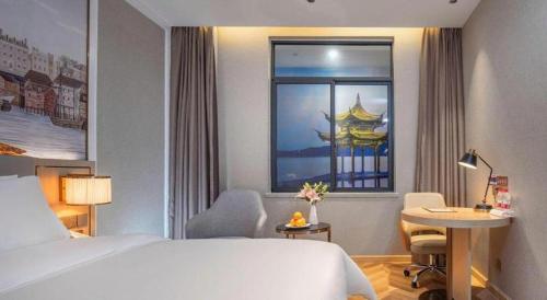 a hotel room with a bed and a window at Vienna Hotel Hangzhou East Railway Station West Square in Hangzhou