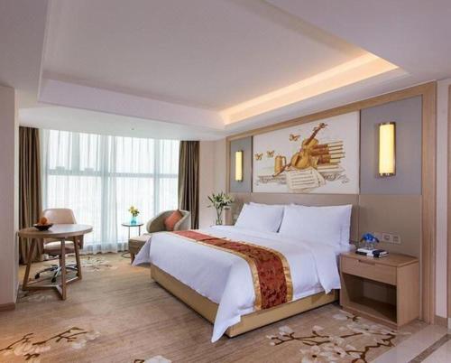 a hotel room with a large bed and a desk at Venus International Hotel Guangdong Meizhou Fengshun Huamao Hot-Spring in Tangkeng