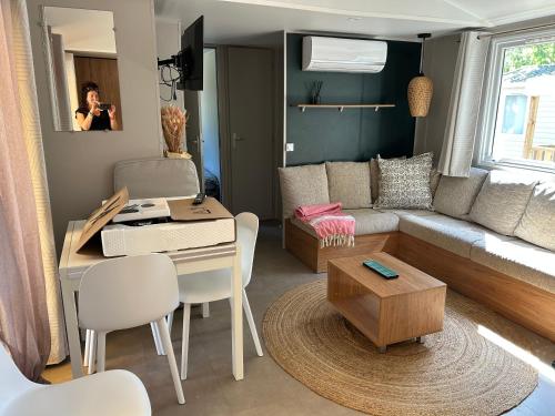 un petit salon avec une table et un canapé dans l'établissement Mobilhome Mimizan Plage, à Mimizan
