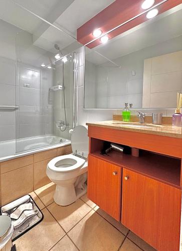 a bathroom with a toilet and a sink and a tub at Centro Temuco 4 in Temuco