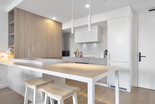 a kitchen with a counter with stools in it at Spacious 2-Bed Apartment in North Fremantle in North Fremantle