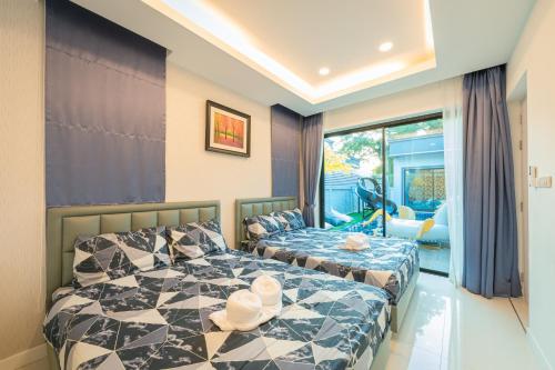 Un dormitorio con dos camas y una ventana. en Gallery Na Jomtien, en Na Jomtien