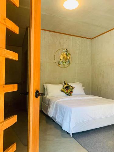 ein Schlafzimmer mit einem Bett in einem Zimmer mit einer Tür in der Unterkunft Mulawin B&B in El Nido