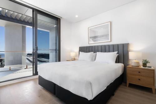 a bedroom with a large bed and a large window at Penthouse Stay With Ocean Views in North Fremantle