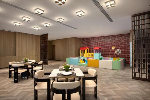 a restaurant with tables and chairs and a playground at Crowne Plaza Putian by IHG in Putian