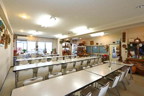 a restaurant with rows of tables and chairs at Greenchair AMANO in Yamanakako