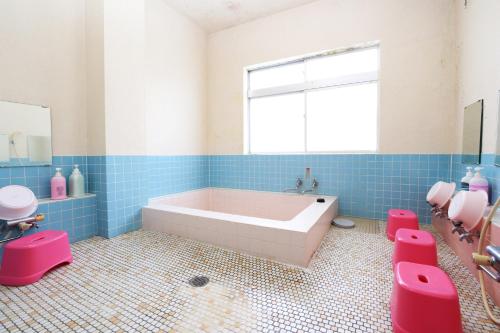 a bathroom with a tub and a window and pink toilets at Greenchair AMANO in Yamanakako
