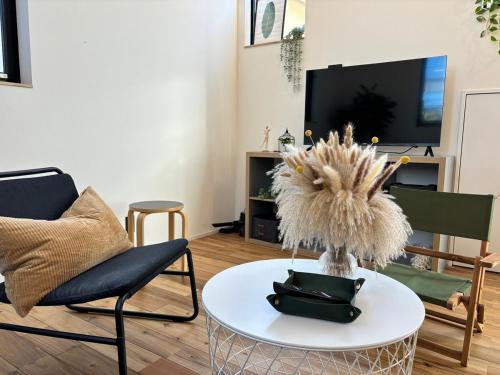 a living room with a table and chairs and a tv at Near JR Kameari Tokyo - Shades of Green - Japanese House for up to 6 Guests in Tokyo