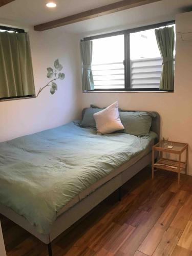 a small bed in a room with two windows at Near JR Kameari Tokyo - Shades of Green - Japanese House for up to 6 Guests in Tokyo