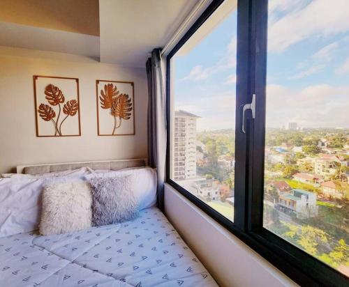 a bed in a room with a large window at Preum Properties Tagaytay in Tagaytay