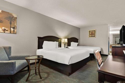 a hotel room with a large bed and a chair at Rodeway Inn Lumberton Central in Lumberton