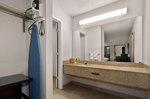 a bathroom with a sink and a large mirror at Rodeway Inn Lumberton Central in Lumberton