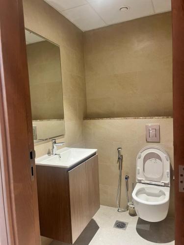 a bathroom with a toilet and a sink and a mirror at EC Holiday Homes Dubai Al Furjan in Dubai