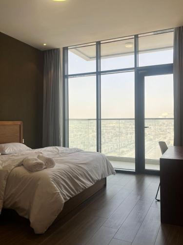a bedroom with a bed and a large window at EC Holiday Homes Dubai Al Furjan in Dubai