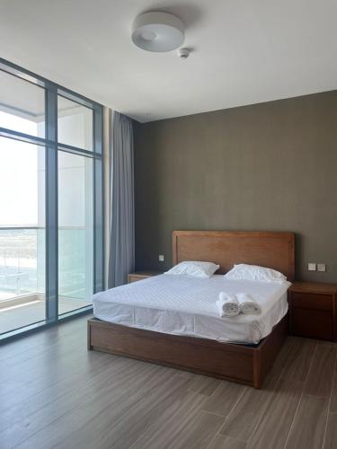 a bedroom with a bed and a large window at EC Holiday Homes Dubai Al Furjan in Dubai