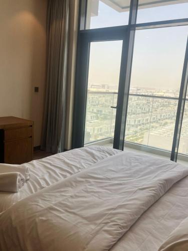 a bed in a room with a large window at EC Holiday Homes Dubai Al Furjan in Dubai