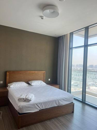 a bedroom with a bed and a large window at EC Holiday Homes Dubai Al Furjan in Dubai
