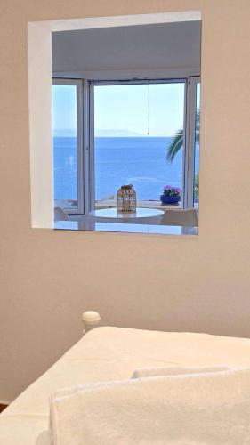 a bedroom with a window with a view of the ocean at Heavens View in Pyrgi