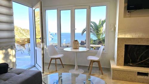 a living room with a table and chairs and a fireplace at Heavens View in Pyrgi