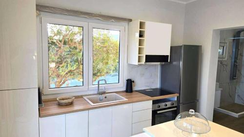 a kitchen with a sink and a large window at Heavens View in Pyrgi