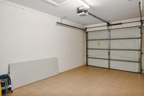 an empty garage with white walls and white garage doors at Kingfisher Apartment in Hallidays Point