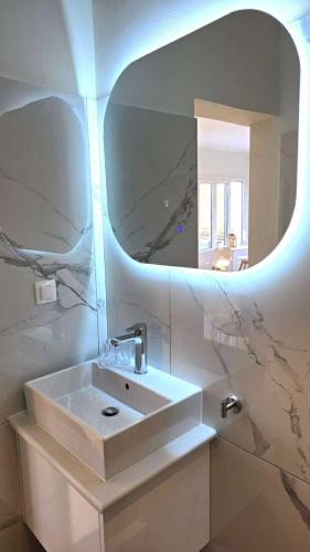 a bathroom with a white sink and a mirror at Heavens View in Pyrgi