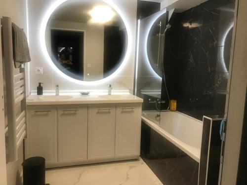 a bathroom with a sink and a tub and a mirror at Loft 90m2 avec spa chauffé unique à Lyon in Lyon