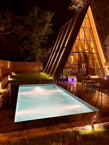 a swimming pool at night in front of a building at Dunewood Resorts in Ani
