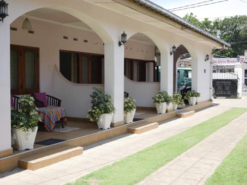 a porch of a house with potted plants on it at Ocean View tourist guest house at Negombo beach near the airport in Negombo