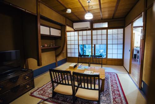 a room with two chairs and a table and a tv at Gojo Miyabi Inn in Kyoto