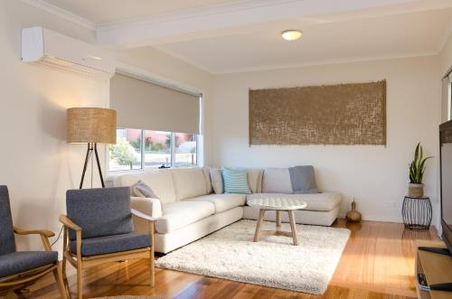 a living room with a white couch and a table at Penguin Beach House in Penguin