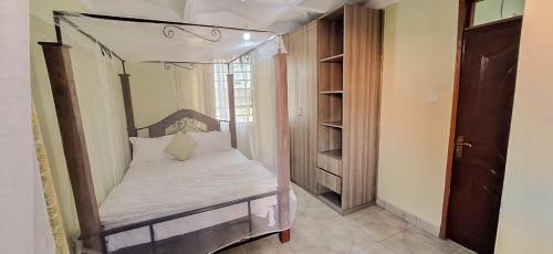 a bed with a canopy in a room at Zedek Suites in Nairobi