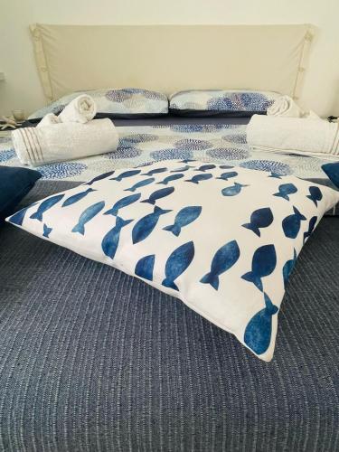 a bed with a blue and white blanket with dolphins on it at SoverHouse affittacamere a Soverato Marina in Soverato Marina