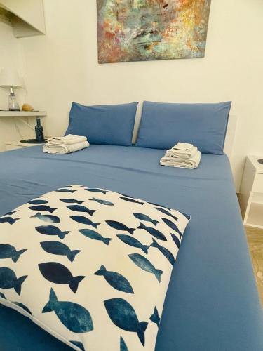 a bed with a blue and white bedspread with dolphins on it at SoverHouse affittacamere a Soverato Marina in Soverato Marina