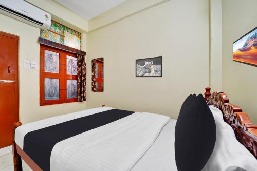 a bedroom with a white and black bed and a tv at Super Hotel O Erode Bus Stand in Erode