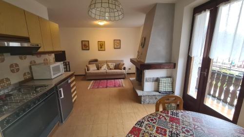 a kitchen and living room with a couch and a table at Bioledro - Casa Lena in Mezzolago